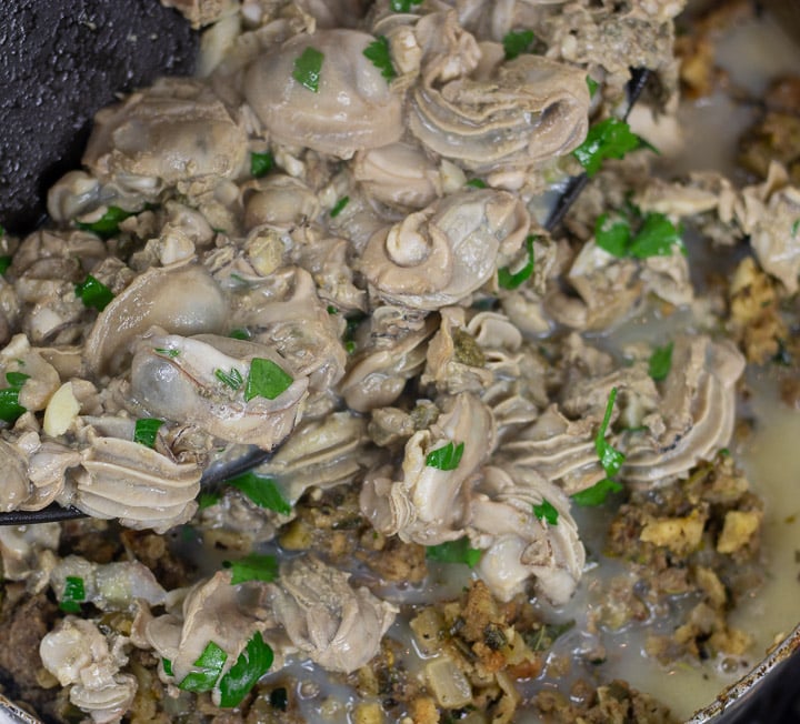 sauteed oyster added to dressing in a frying pan for oyster dressing