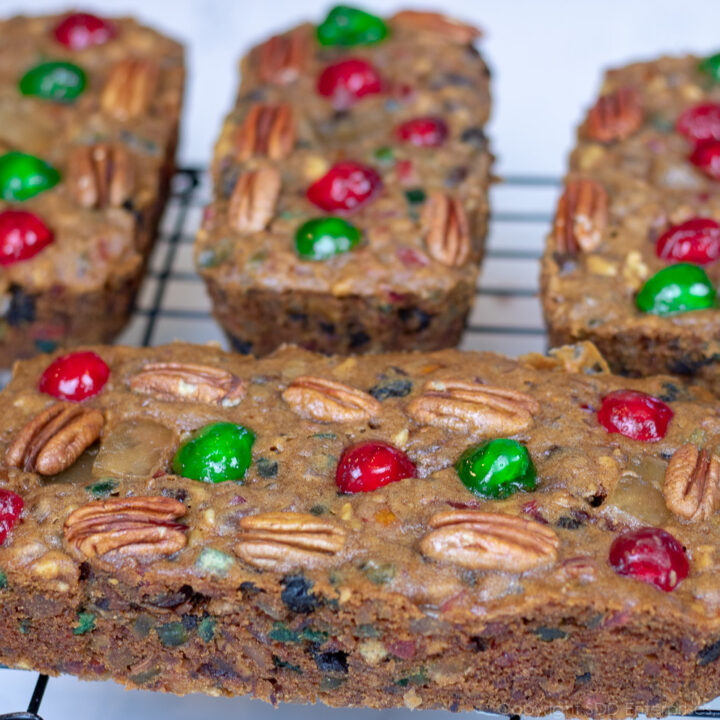 four fruitcakes on a cooling rack