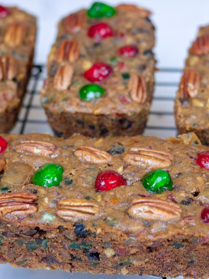 four fruitcakes on a cooling rack