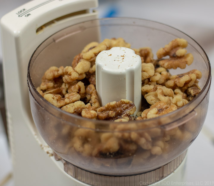 Walnuts and pecans in a small food chopper.