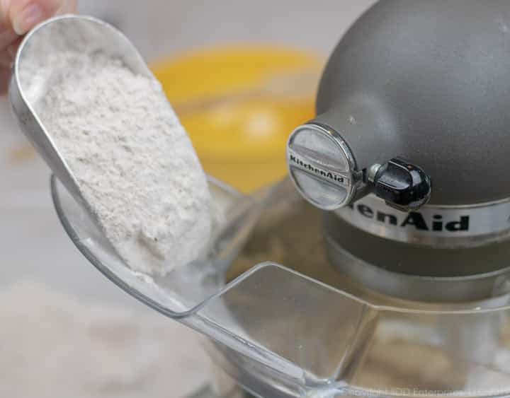 Sifted flour and spices being added to mixing bowl for fruitcake.