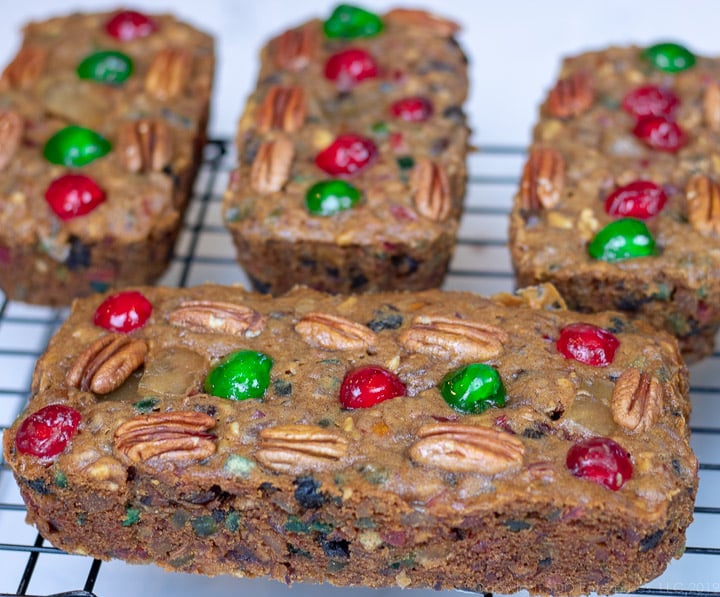 four fruitcakes on a cooling rack