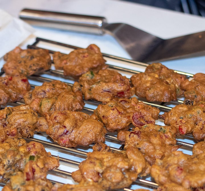 fruitcake cookies on a cooling rack with a spatchula