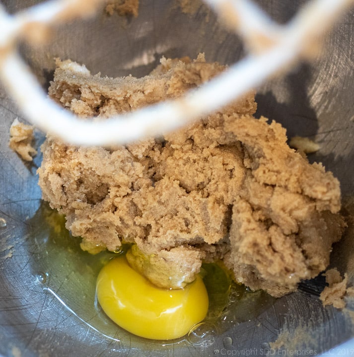 one egg added to mixing bowl for fruitcake cookies