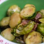 roasted brussels sprouts with pancetta in a green bowl
