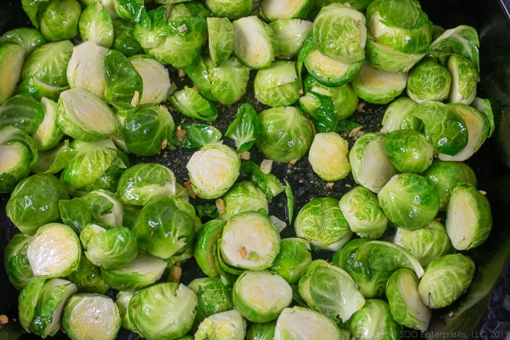 brussels sprouts sauteig in the pancetta fat with garlic in a cast iron pan