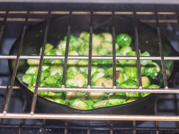 brussels sprouts in the cast iron pan placed in the oven