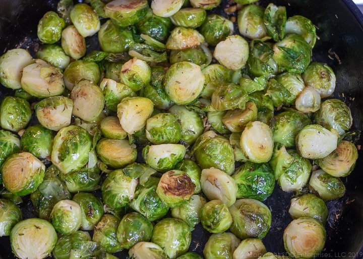 sauteed brussels sprouts with herbs in a cast iron pan