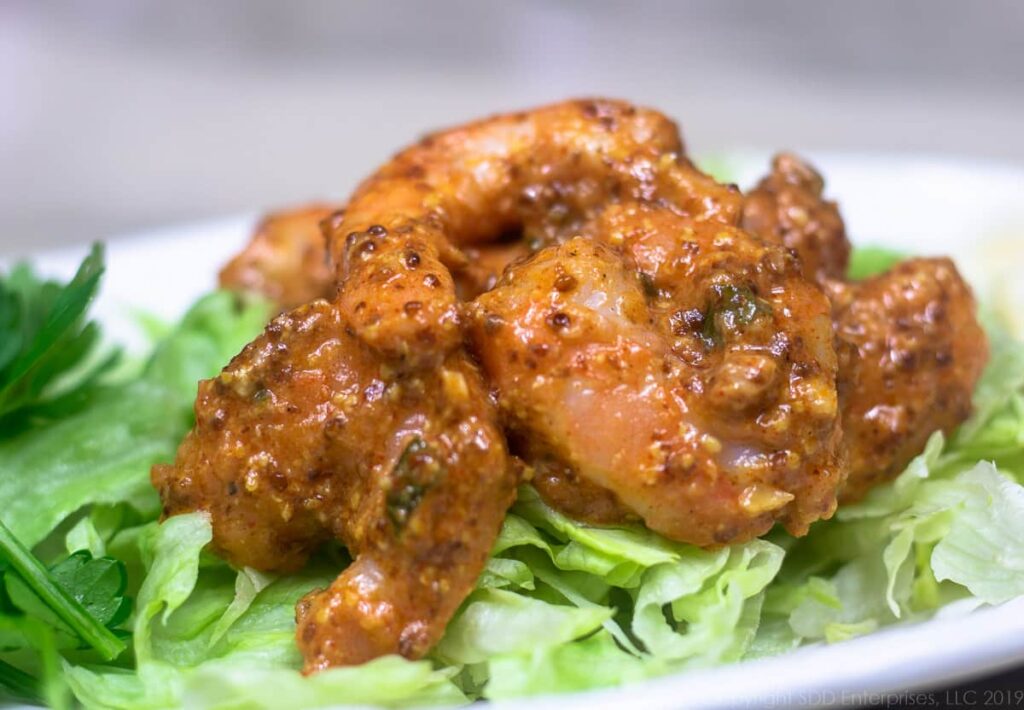 shrimp remoulade on a bed of iceberg lettuce with a parsley garnish