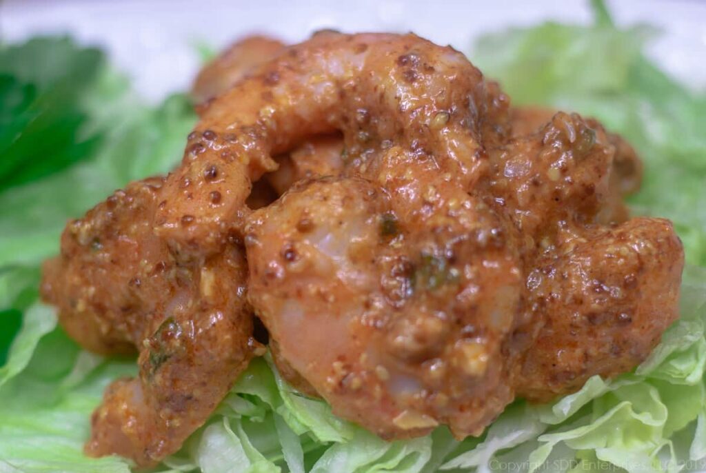 chilled cooked shrimp in remoulade sauce served on a bed of iceberg lettuce and a pasrsley garnish