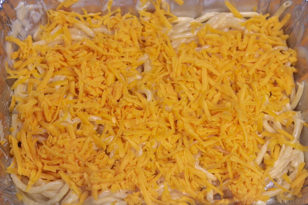noodles in cheese sauce covered with grated cheese for macaroni and cheese