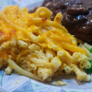 macaroni and cheese on aplate with beef patty and green beans