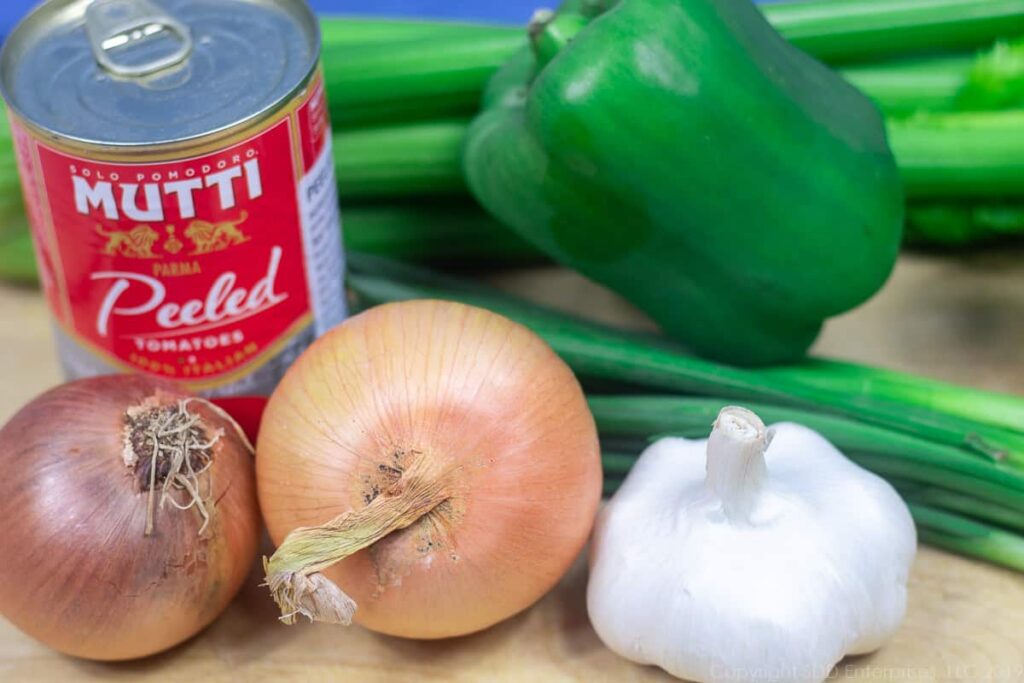 onions, bell peppers, green onions and celery with a can of tomatoes