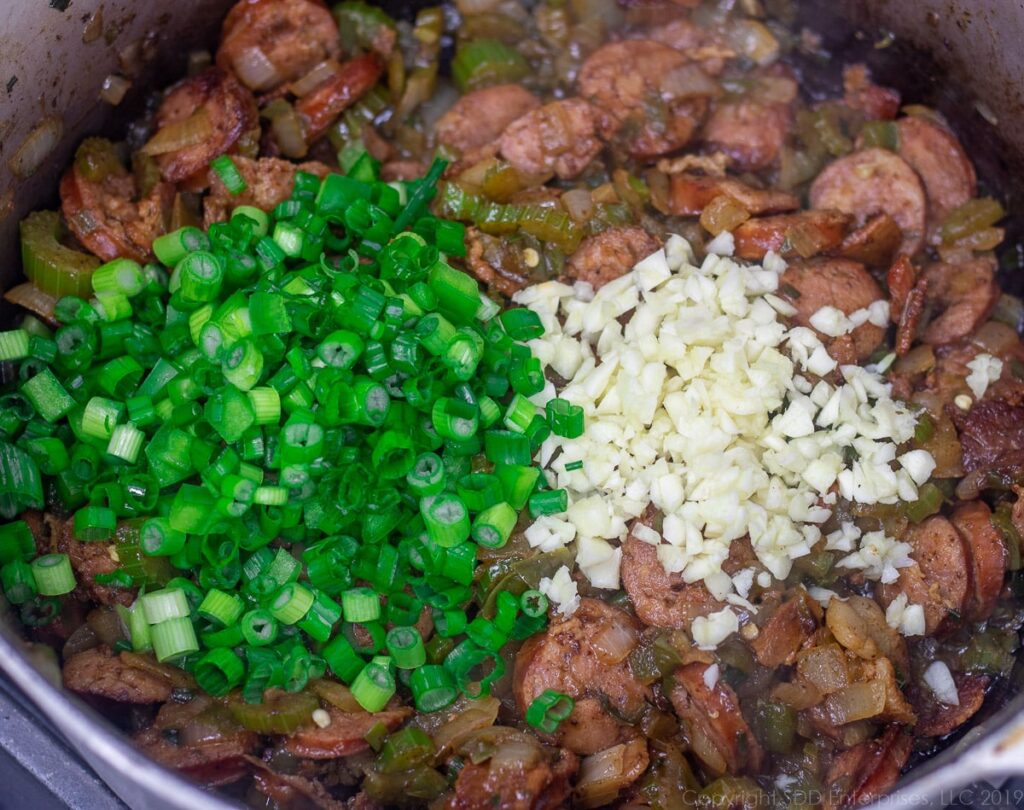 green onions and garlic added to the dutch oven for creole jambalaya
