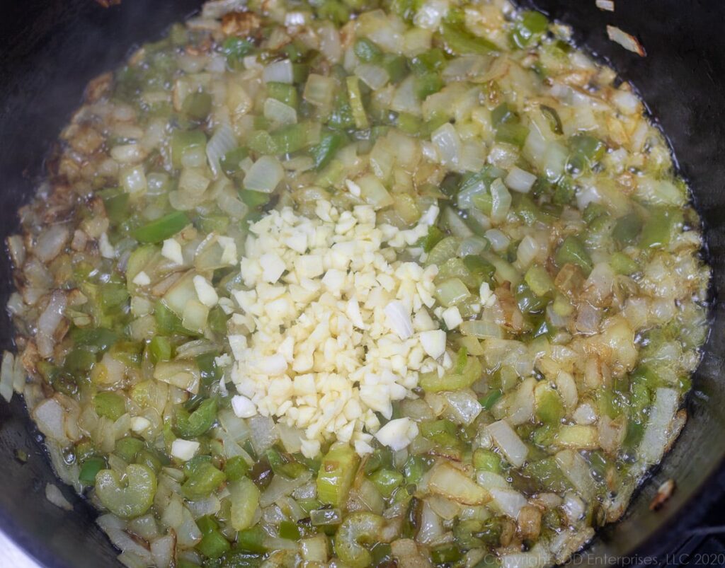 garlic added t the trinity cooking in a dutch oven