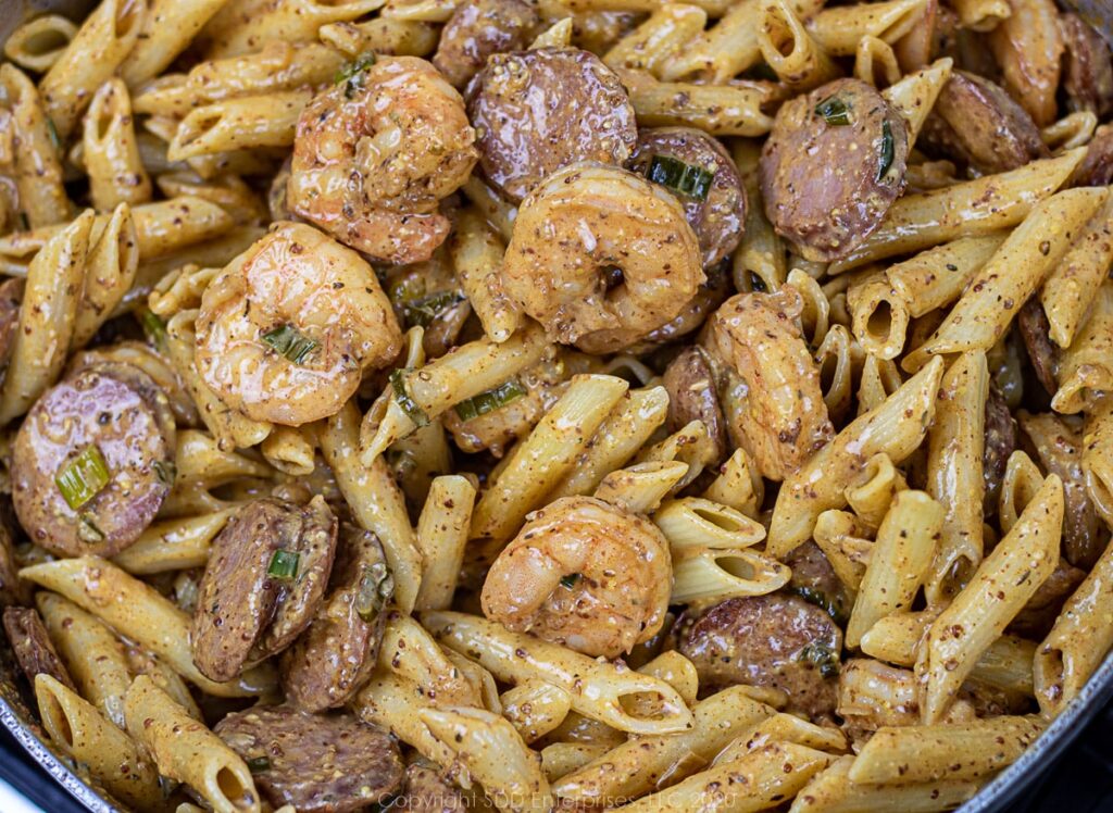 shrimp and andouille in a creole mustard cream sauce in a frying pan
