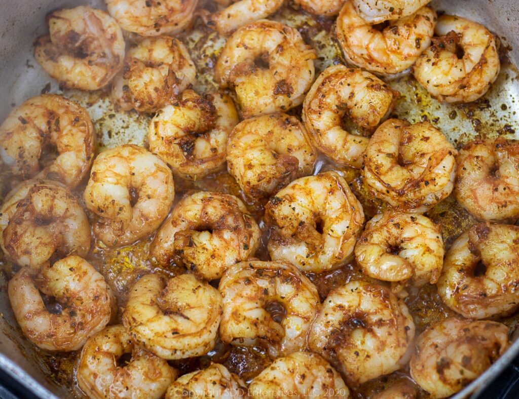 shrimp in spices sauteed in a frying pan