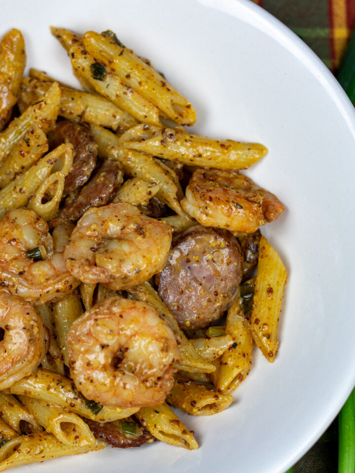 pasta with shrimp and sausage in a white bowl