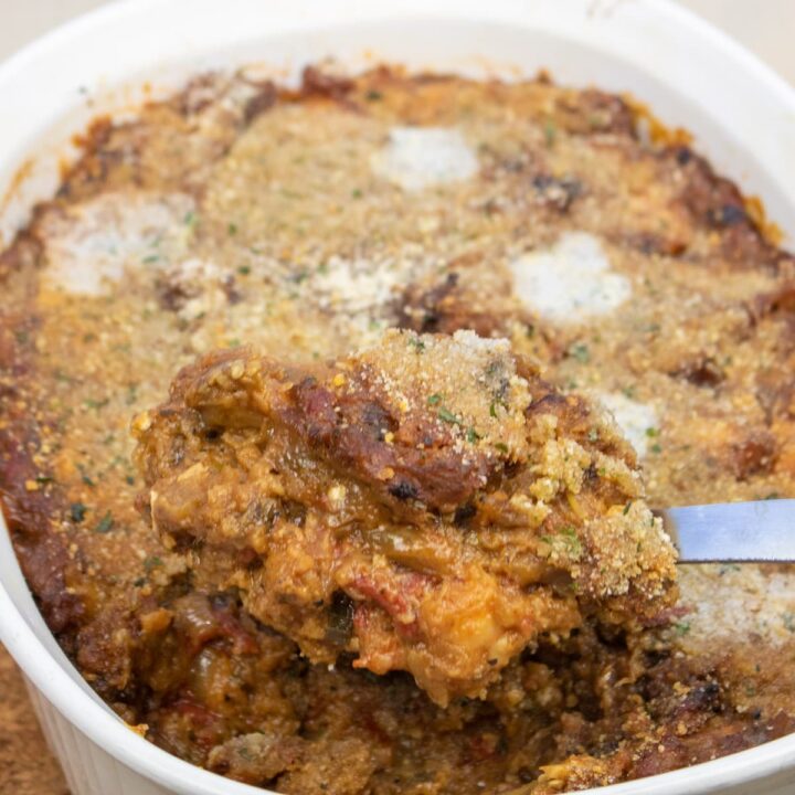 creole eggplant casserole in a baking dish with a spoon of casserole