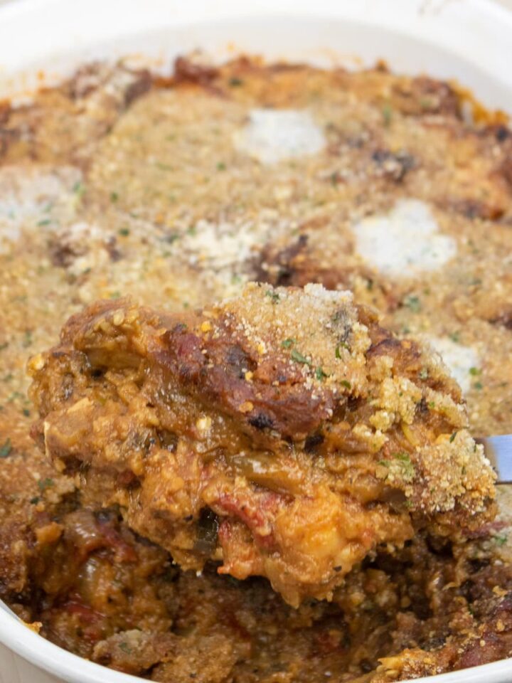 creole eggplant casserole in a baking dish with a spoon of casserole