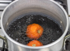 two tomatoes in boiling water