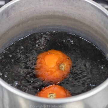 two tomatoes in boiling water