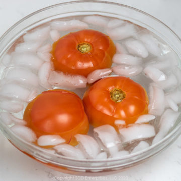 three tomatoes in an ice bath