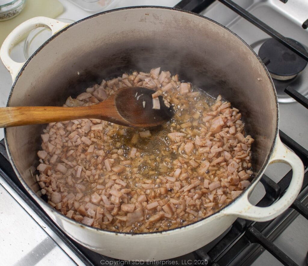 ham frying in bacon grease in a dutch oven