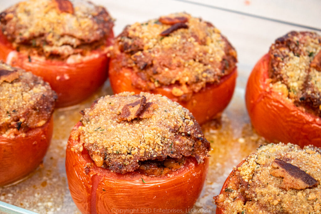 5 stuffed tomatoes with topping in a baking dish