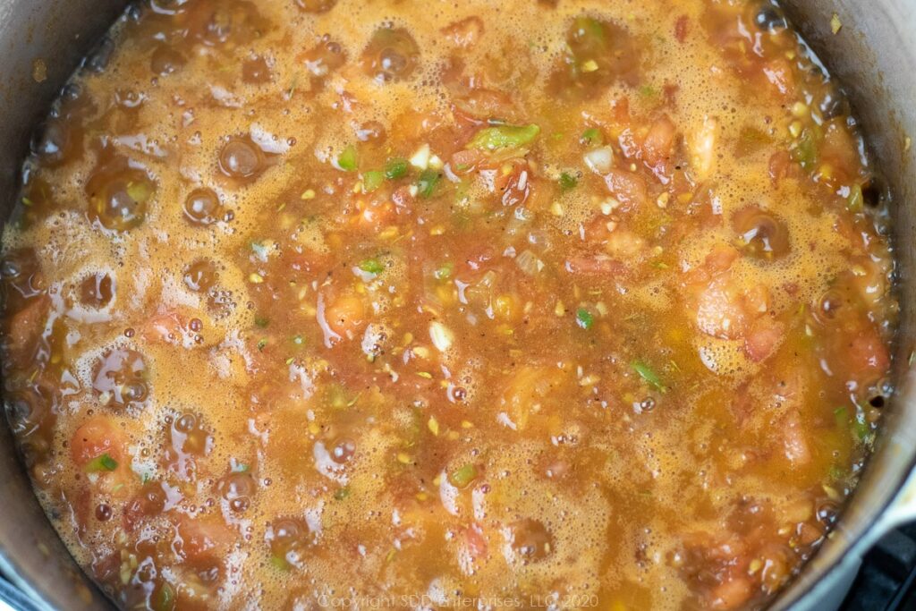 vegetables and tomatoes simmering in a dutch oven