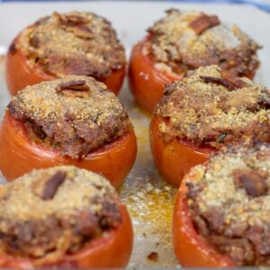 six stuffed tomatoes in a baking dish