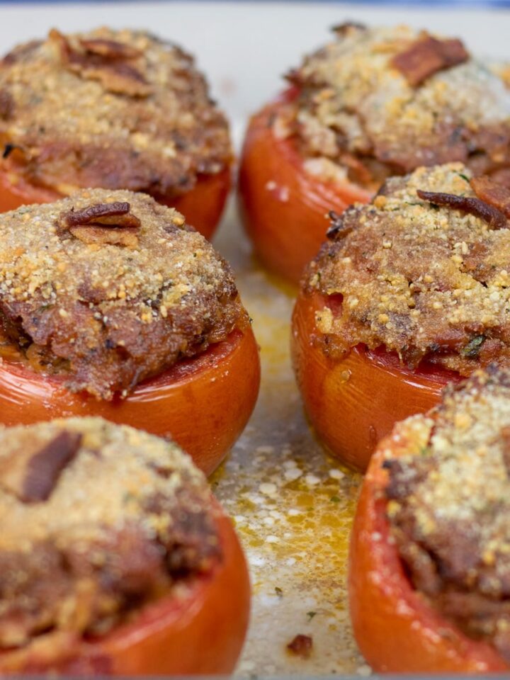 six stuffed tomatoes in a baking dish