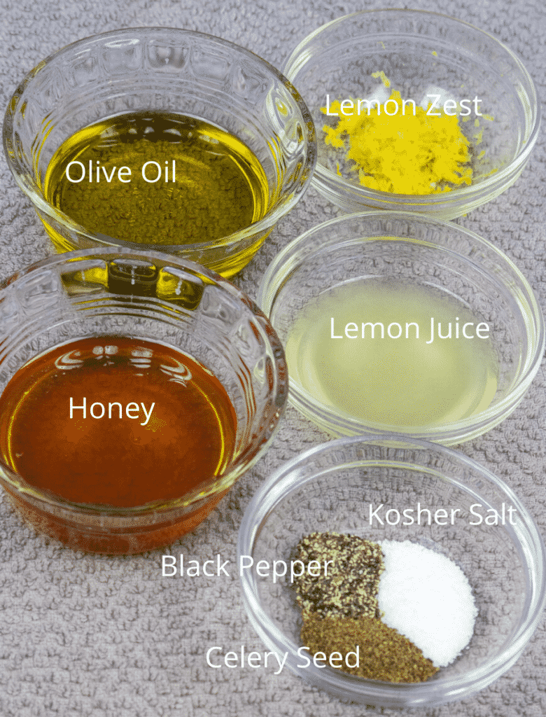 honey, olive oil, spices, lemon zest and lemon juice in prep bowls for slaw dressing