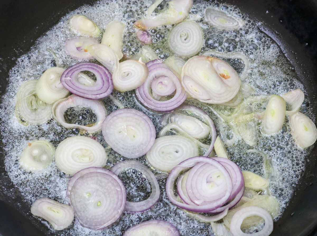 shallots sauteing in butter in a skillet