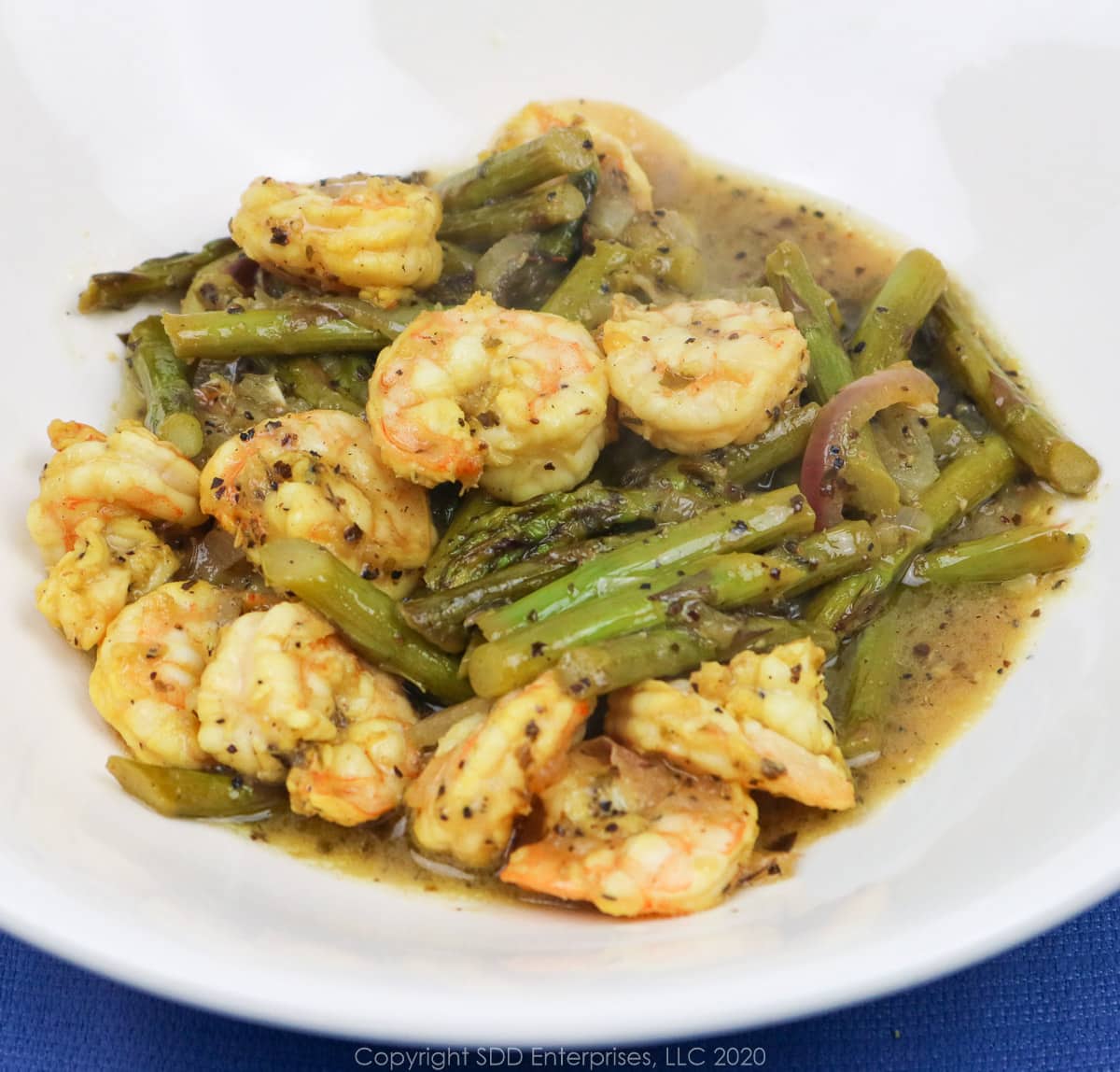 sauteed shrimp and asparagus in a white bowl