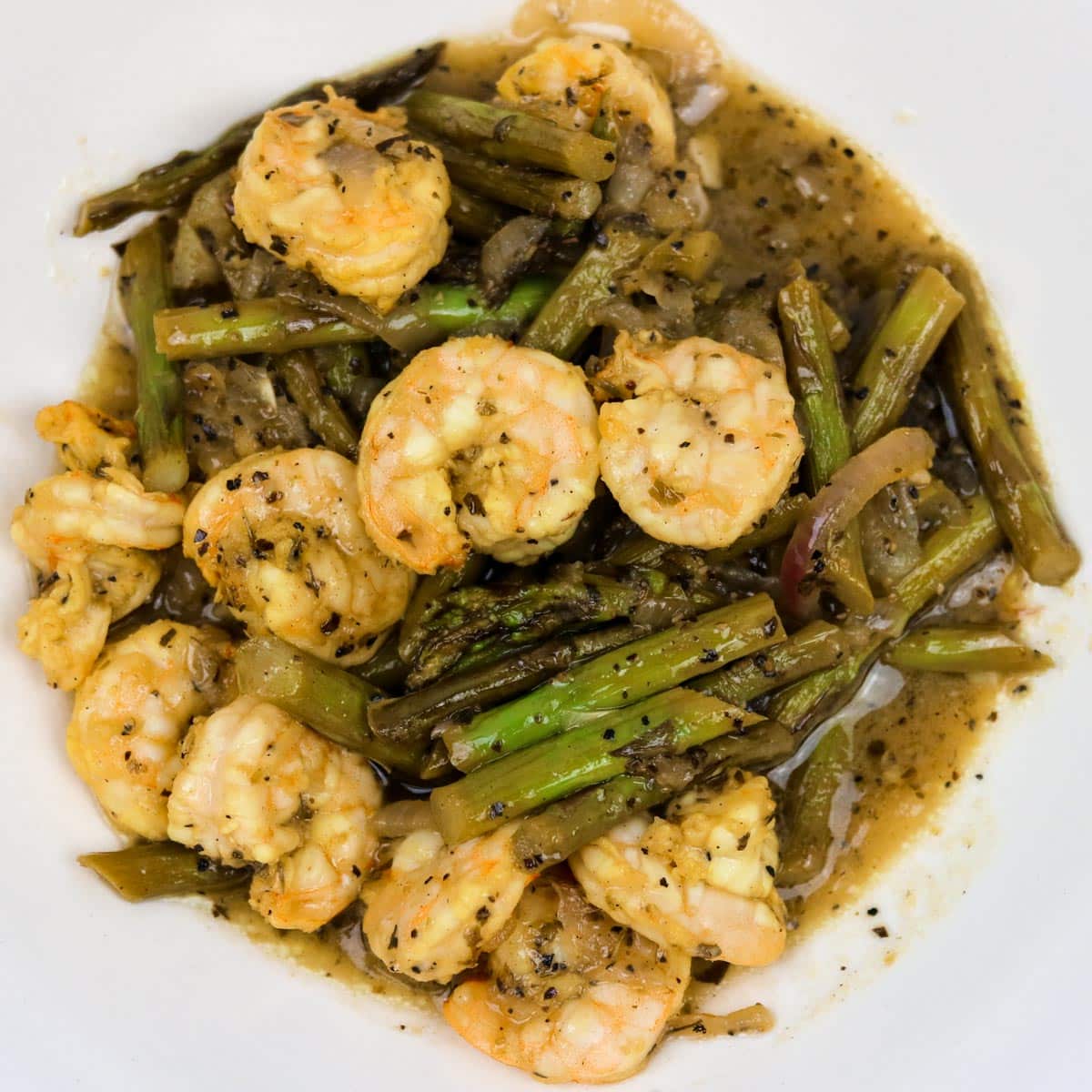 sauteed shrimp with asparagus in a white bowl