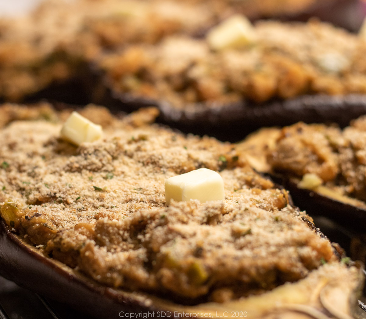 stuffed eggplant with breadcrumb topping and butter ready for the oven