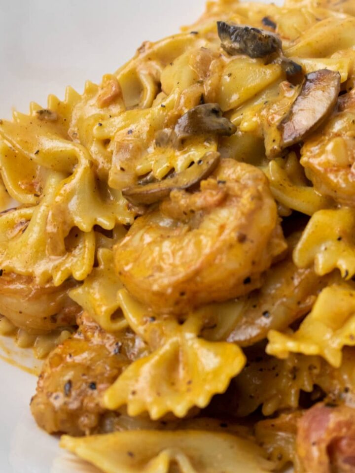 shrimp with pasta in a creamy mushroom sauce in a white bowl
