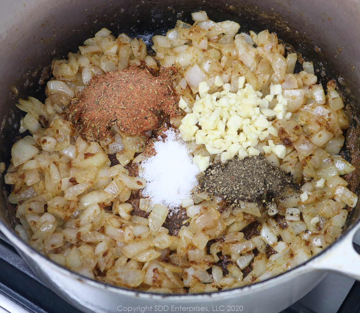 creole seasoning, salt and pepper and chopped garlic added to onions frying in a dutch oven