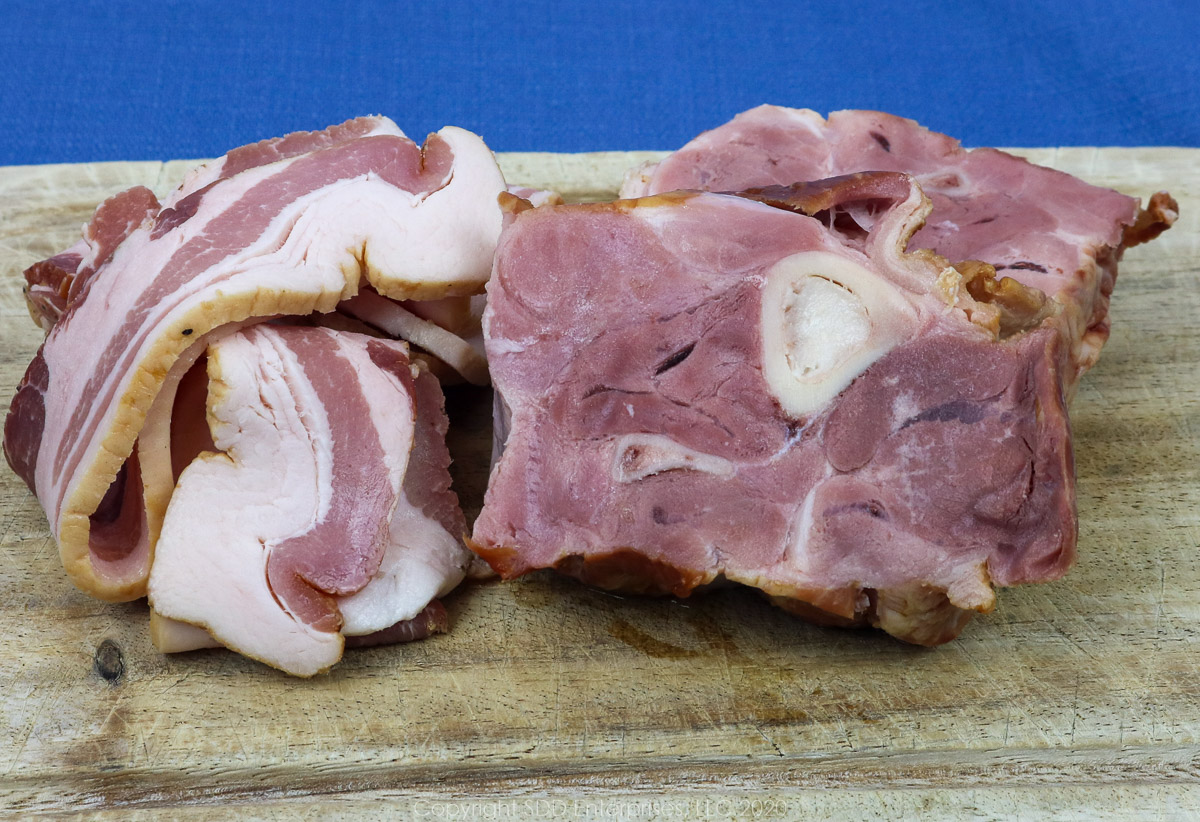 uncooked bacon and smoked ham shanks on a cutting board