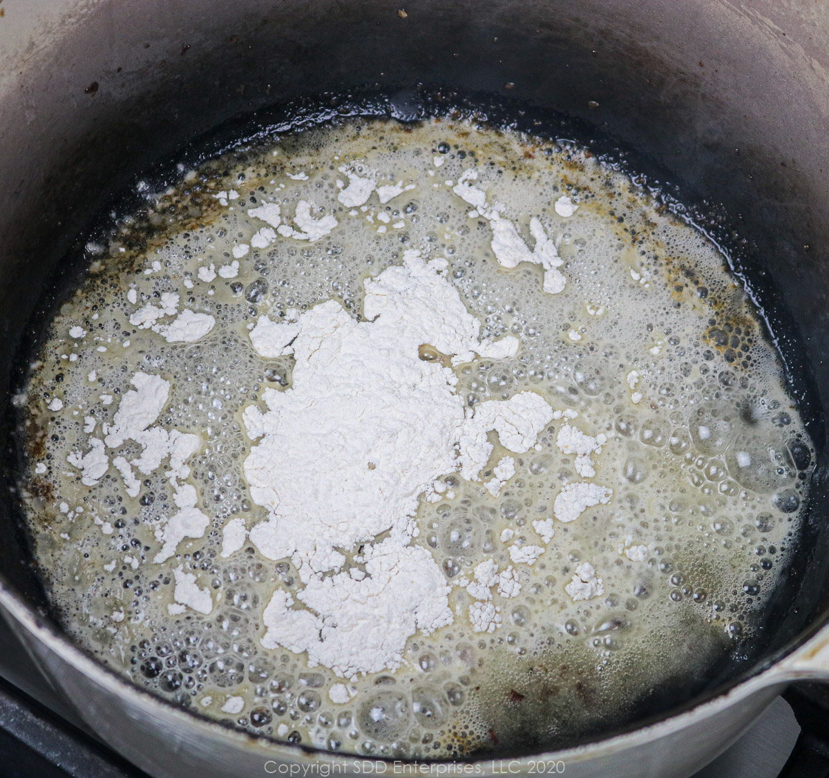 all-purpose flour added to bacon grease in a dutch oven to make a roux