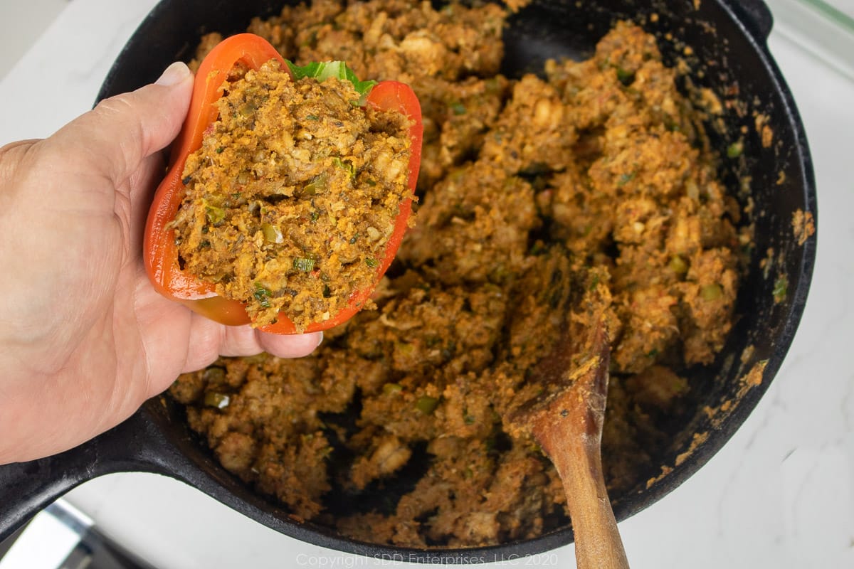 crawfish stuffing placed in a hlaf bell pepper over a dutch oven of stuffing