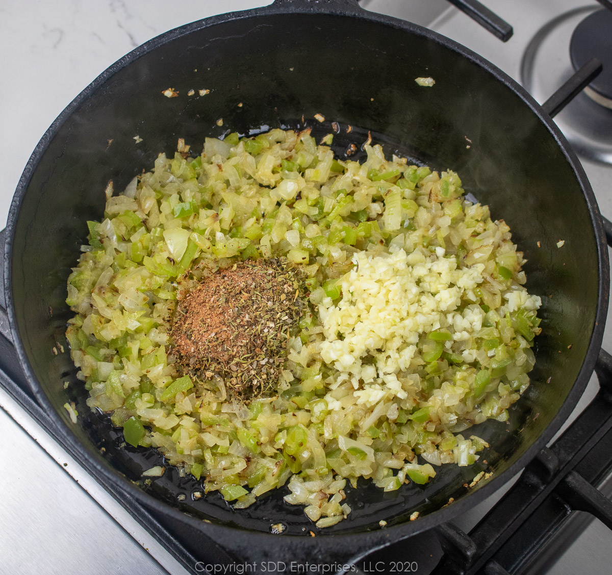 garlic and creole seasoning added to the sauteed trinity in a dutch oven