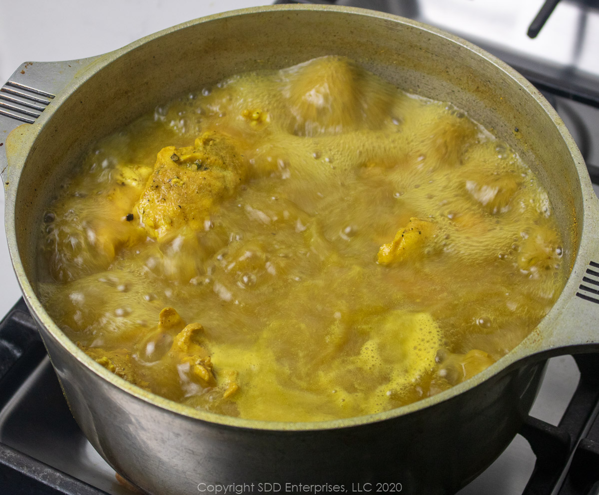 chicken breasts and spices in a stock pot with boiling water