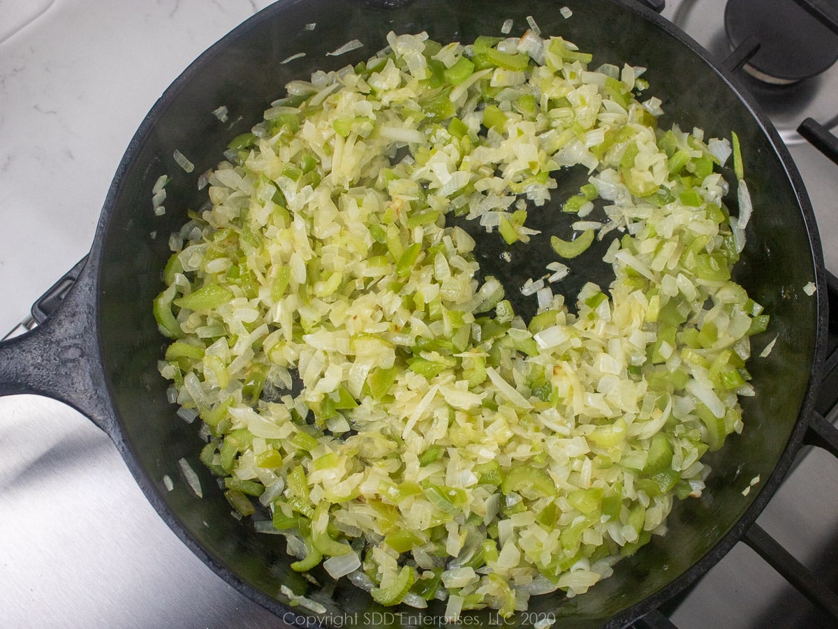 the trinity frying in butter in a cast iron pan