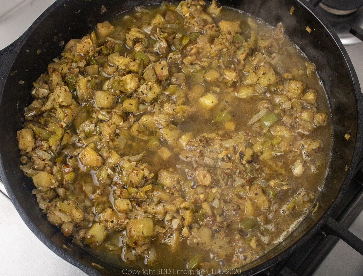 stock in a cast iton pan with sauteed vegetables 