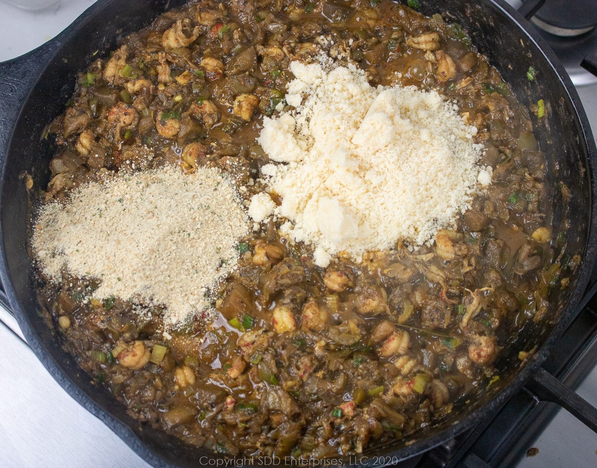 breadcrumbs and Parmesan cheese added to a frying pan with sauteed vegetables