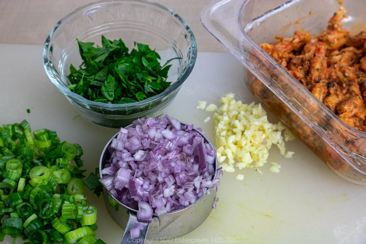 chopped green onions, shallots, garlic, parsley and crawfish tails for crawfish cream sauce