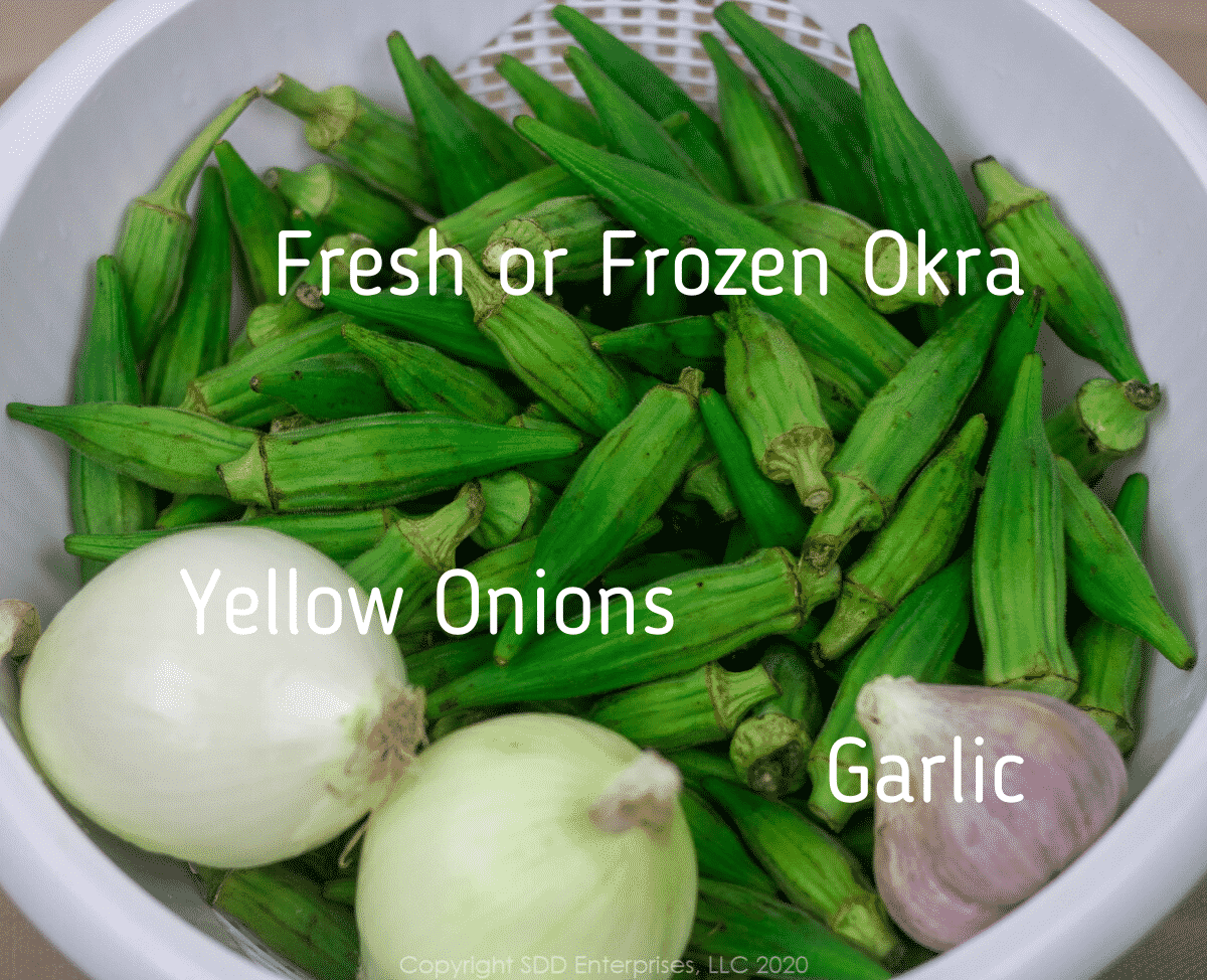 a clear bowl with whole okra, two yellow onions and a garlic pod and graphics