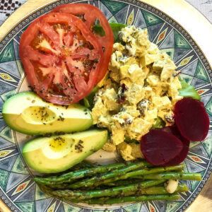 chicken salad, beets, asparagus, avacado and tomatoes on a plate with green trim